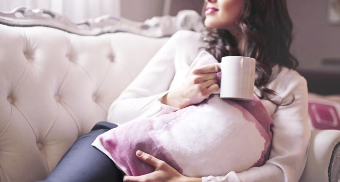 Woman Relaxing with a Cup of Coffee While Her House Is Being Cleaned.